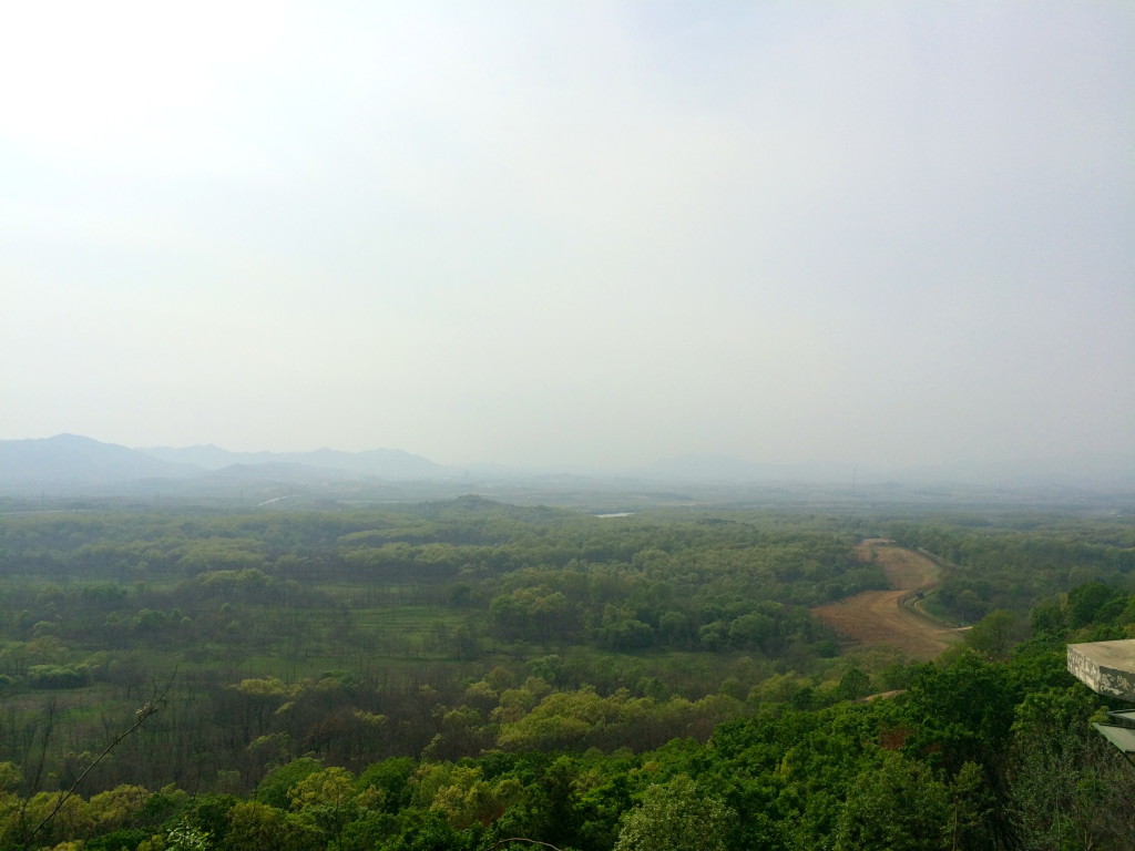 A naked-eye view of North Korea. The border is in the trees, and the end of the DMZ is where the trees end.