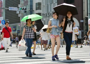 Pedestrians use their parasols to avoid strong sunlight in Tokyo on June 1, 2014. Tokyo's temperature climbed over 33 degree Celsius on June 1, with two women dead near Tokyo on May 31, with both suspected of suffering heatstroke. AFP PHOTO / Yoshikazu TSUNO